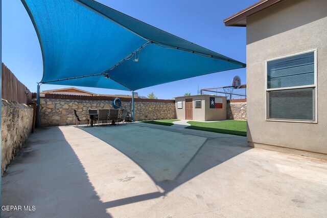 10677 Canyon Sage Dr, El Paso, TX 79924 - view of patio featuring an outdoor structure, a fenced backyard, a storage shed, and outdoor dining space
