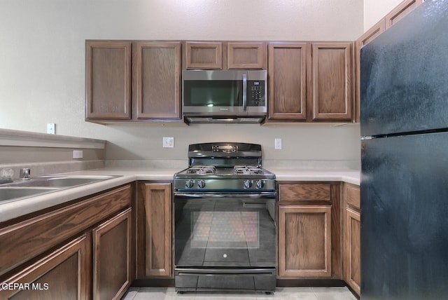 10677 Canyon Sage Dr, El Paso, TX 79924 - kitchen with black appliances, light countertops, light tile patterned flooring, and a sink