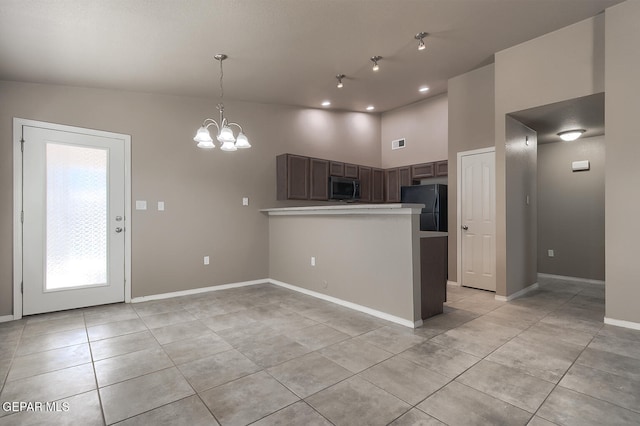 10677 Canyon Sage Dr, El Paso, TX 79924 - kitchen with stainless steel microwave, freestanding refrigerator, light tile patterned floors, a peninsula, and a towering ceiling