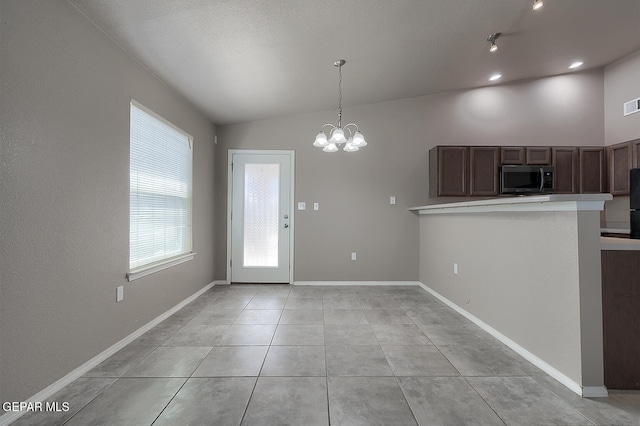10677 Canyon Sage Dr, El Paso, TX 79924 - kitchen featuring stainless steel microwave, lofted ceiling, a chandelier, decorative light fixtures, and a peninsula