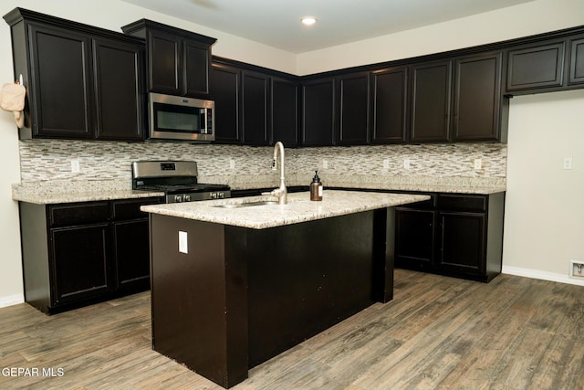 756 Jalynn Grace, Canutillo, TX 79835 - kitchen featuring appliances with stainless steel finishes, dark cabinets, wood finished floors, tasteful backsplash, and recessed lighting