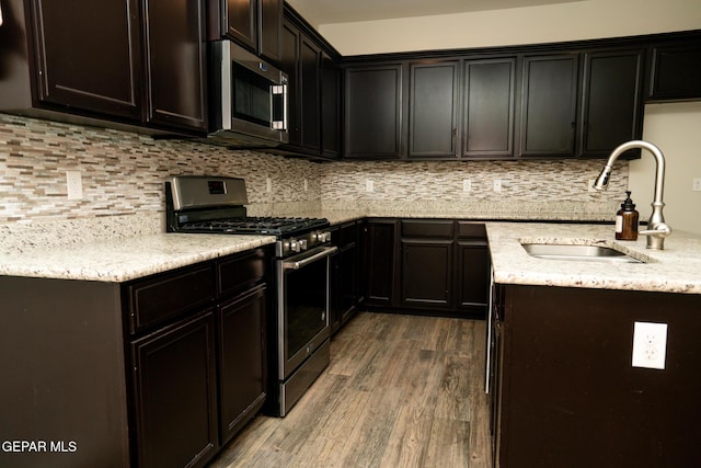 756 Jalynn Grace, Canutillo, TX 79835 - kitchen featuring appliances with stainless steel finishes, wood finished floors, light stone countertops, and backsplash