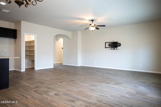 756 Jalynn Grace, Canutillo, TX 79835 - unfurnished living room with arched walkways, a ceiling fan, and dark wood-style floors