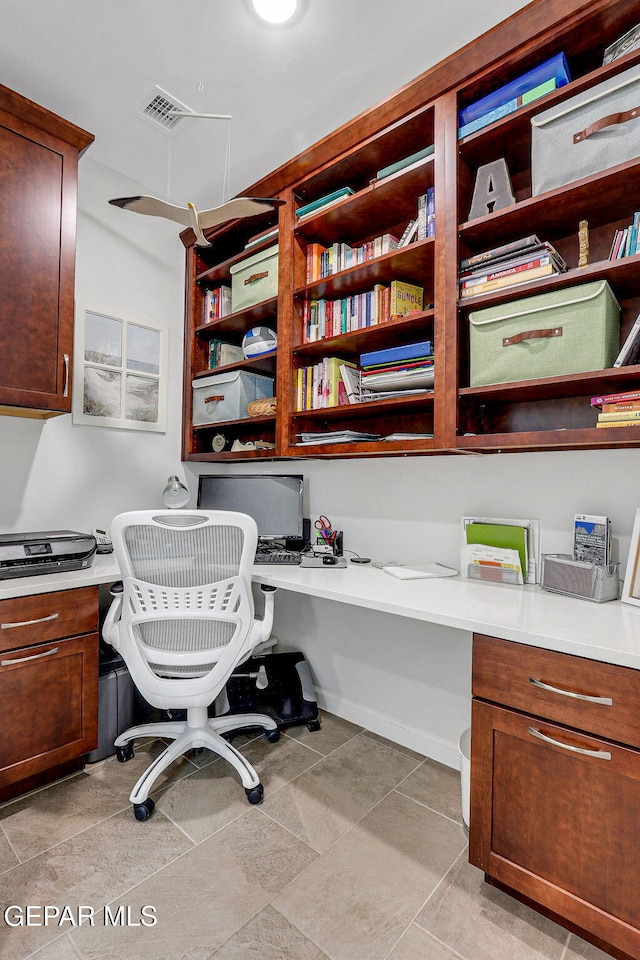 office area featuring built in desk and light tile patterned floors