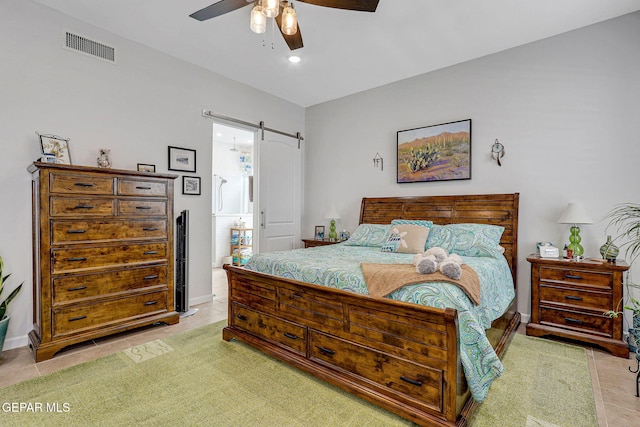 bedroom with a barn door, light tile patterned flooring, visible vents, recessed lighting, and a ceiling fan