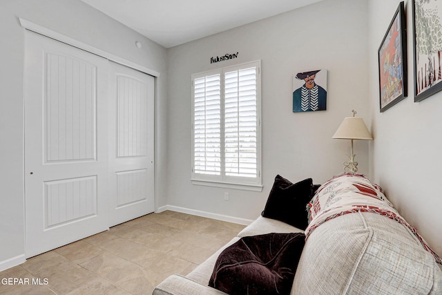 living area with baseboards and light tile patterned floors