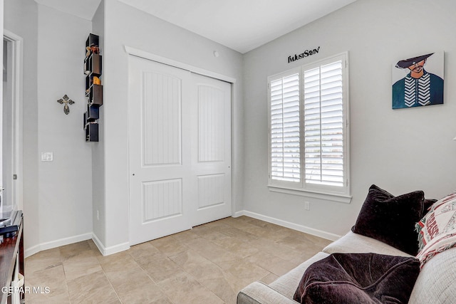 living area featuring baseboards and light tile patterned floors