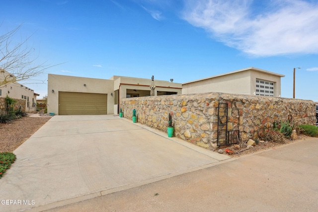 view of front facade featuring a garage, driveway, and stucco siding
