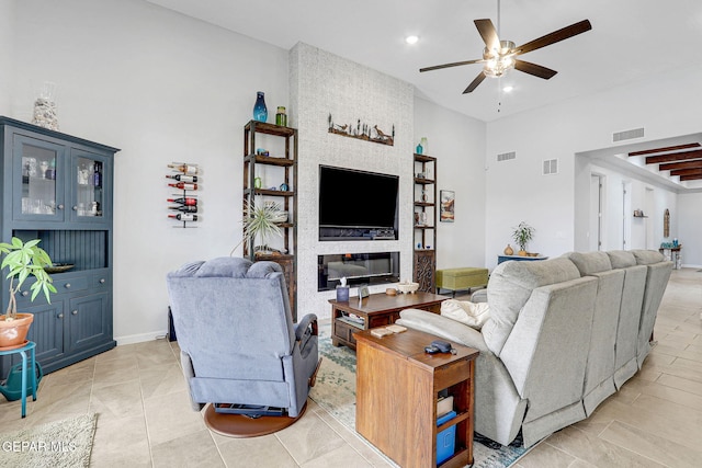 living room with a towering ceiling, visible vents, recessed lighting, and ceiling fan