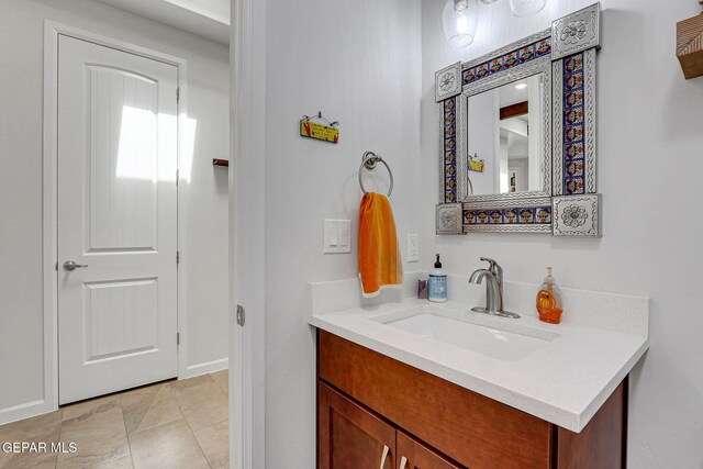 bathroom with baseboards, tile patterned flooring, and vanity