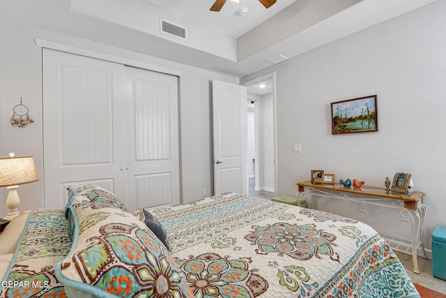 carpeted bedroom with a closet, visible vents, baseboards, and ceiling fan