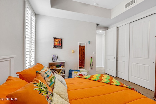 tiled bedroom featuring visible vents and a closet