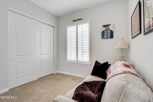 living area featuring light tile patterned flooring and baseboards