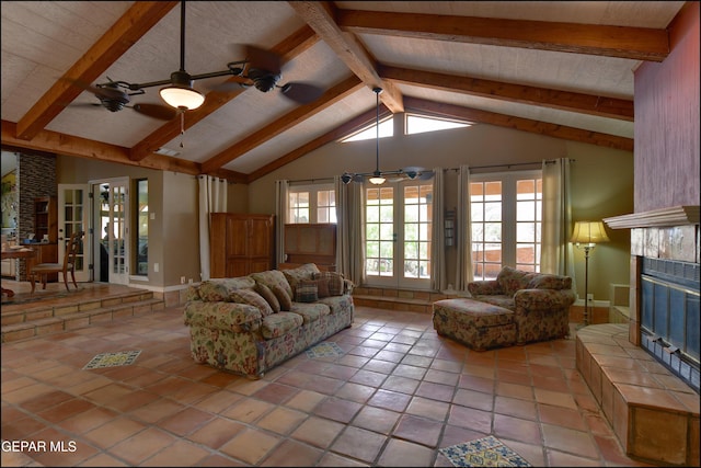 29 Cielo Vis, Anthony, NM 88021 - living room with lofted ceiling with beams, a tile fireplace, tile patterned floors, a ceiling fan, and french doors