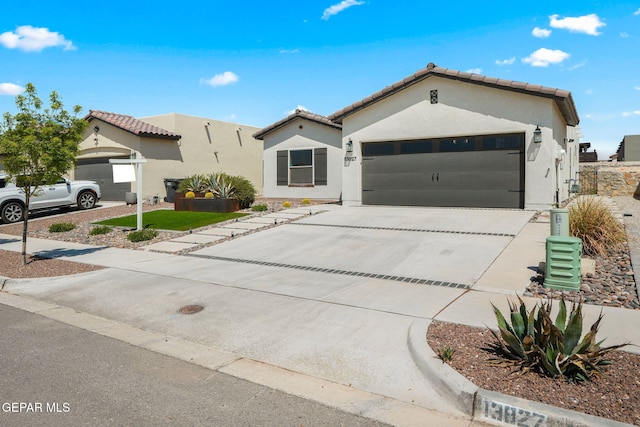view of front of property with concrete driveway, stucco siding, an attached garage, and a tile roof