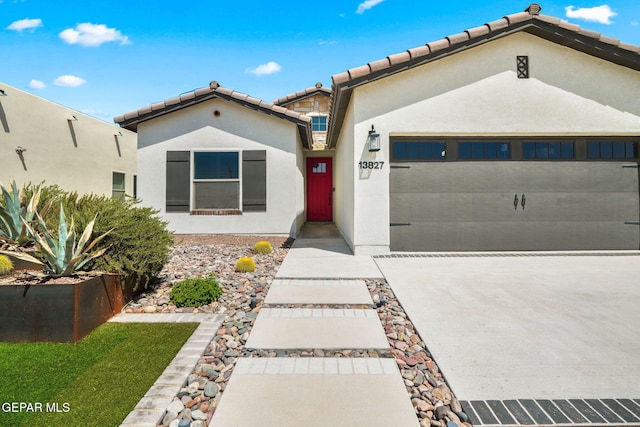 mediterranean / spanish-style house with concrete driveway, stucco siding, a garage, and a tile roof