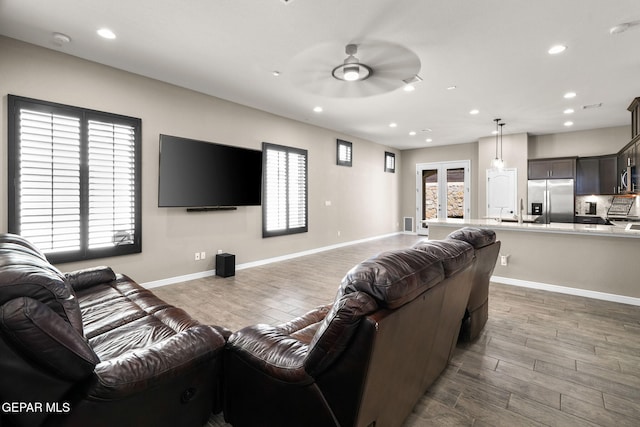 living area with ceiling fan, recessed lighting, wood finished floors, and baseboards