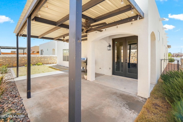 view of patio / terrace with a ceiling fan, french doors, and fence