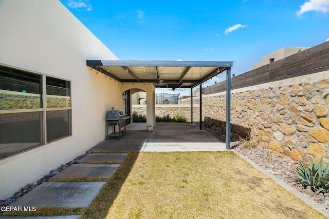 view of yard with a patio area, a fenced backyard, and a ceiling fan