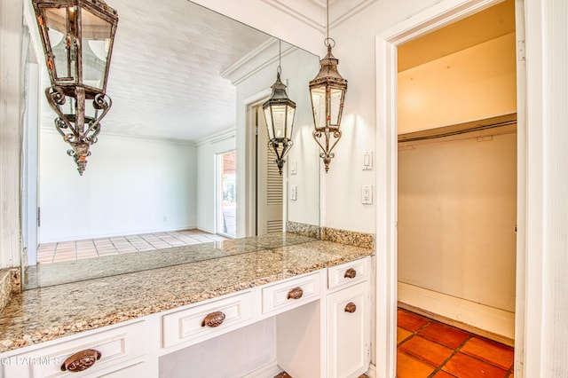 kitchen with built in desk, crown molding, light tile patterned floors, and white cabinetry