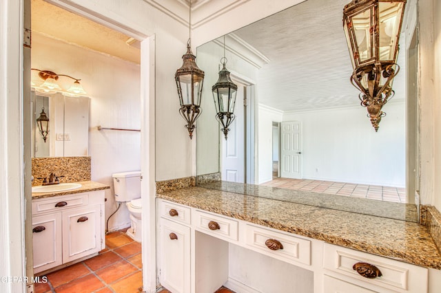 kitchen with tasteful backsplash, light tile patterned floors, a sink, ornamental molding, and white cabinetry