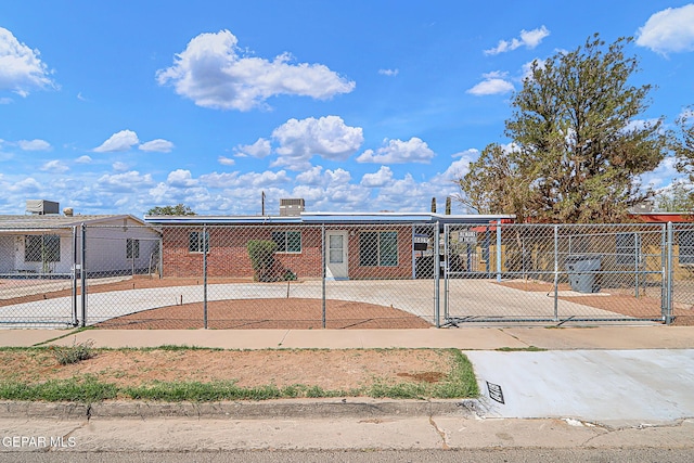 view of front of property with a gate, a fenced front yard, and brick siding