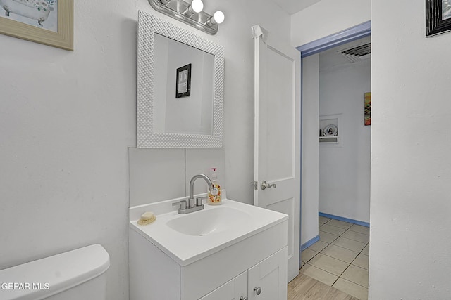 half bathroom with visible vents, toilet, and vanity