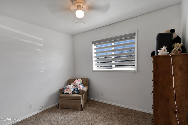 sitting room with baseboards, ceiling fan, and carpet