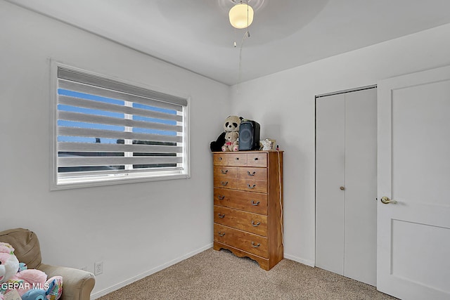 sitting room with baseboards and light colored carpet
