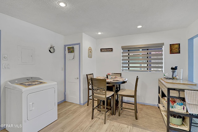 dining area featuring recessed lighting, a textured ceiling, washer / clothes dryer, light wood-style floors, and electric panel