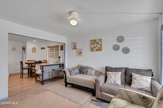 living room featuring a textured ceiling and light wood-type flooring