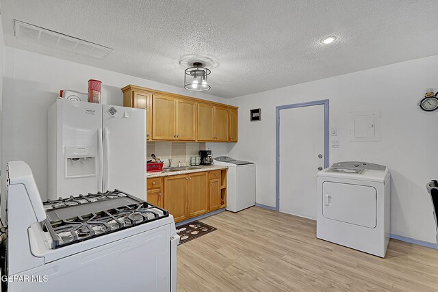 kitchen featuring light wood-style flooring, washer / clothes dryer, visible vents, and white appliances