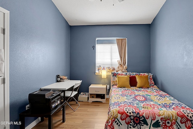 7101 Luz De Sol Dr, El Paso, TX 79912 - bedroom featuring light wood-type flooring, a textured wall, and a textured ceiling
