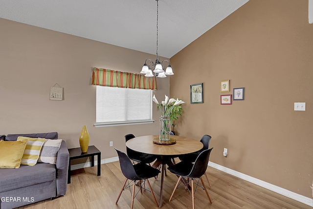 7101 Luz De Sol Dr, El Paso, TX 79912 - dining space with baseboards, light wood finished floors, an inviting chandelier, and vaulted ceiling