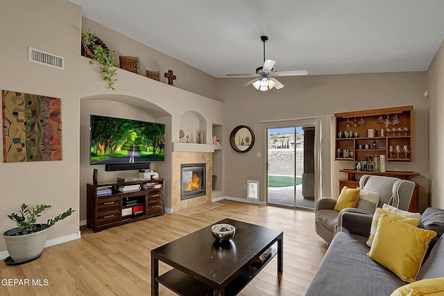 7101 Luz De Sol Dr, El Paso, TX 79912 - living area featuring built in features, a fireplace, light wood-style flooring, a ceiling fan, and visible vents