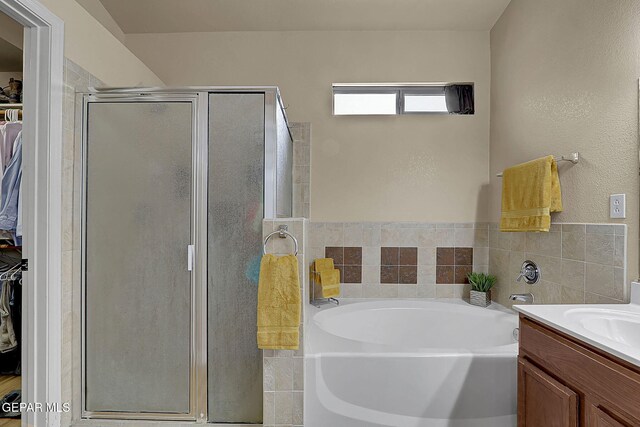 7101 Luz De Sol Dr, El Paso, TX 79912 - bathroom with a spacious closet, vanity, a garden tub, and a stall shower