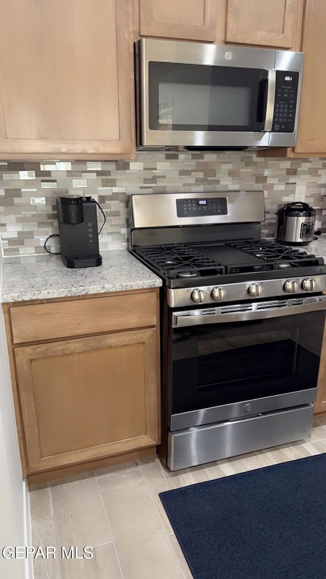 14509 Johnny Mata Dr, El Paso, TX 79938 - kitchen featuring appliances with stainless steel finishes, tasteful backsplash, and light stone counters