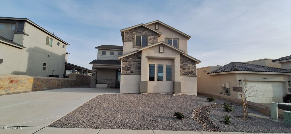 12824 Garden Ridge Dr, Horizon City, TX 79928 - view of front of property featuring stone siding, a garage, concrete driveway, and stucco siding