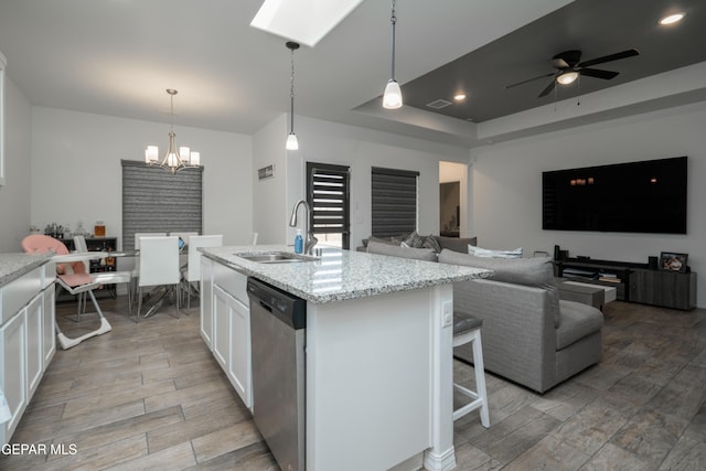 kitchen featuring white cabinetry, dishwasher, a sink, wood tiled floor, and a raised ceiling