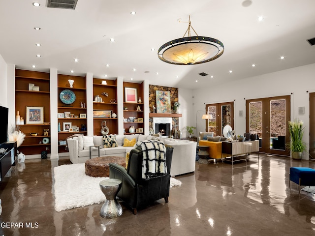 interior space with a stone fireplace, recessed lighting, built in shelves, and visible vents