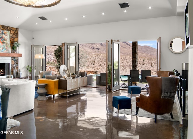 living area with a fireplace, recessed lighting, visible vents, and finished concrete flooring