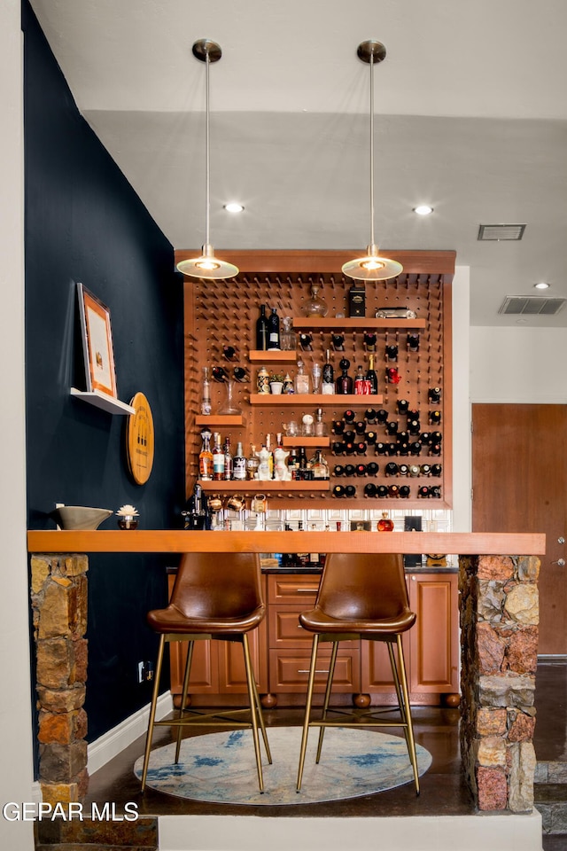 bar featuring hanging light fixtures, a bar, recessed lighting, and visible vents