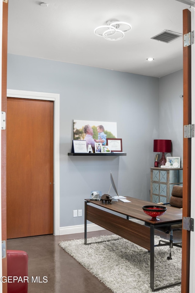home office featuring visible vents, baseboards, and concrete floors