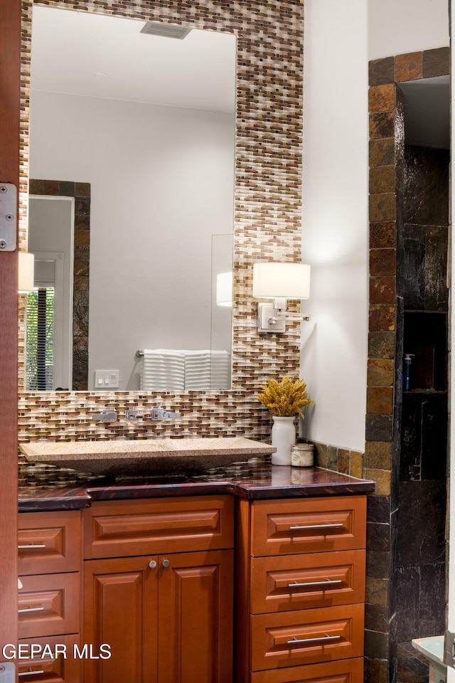 bathroom featuring vanity and backsplash