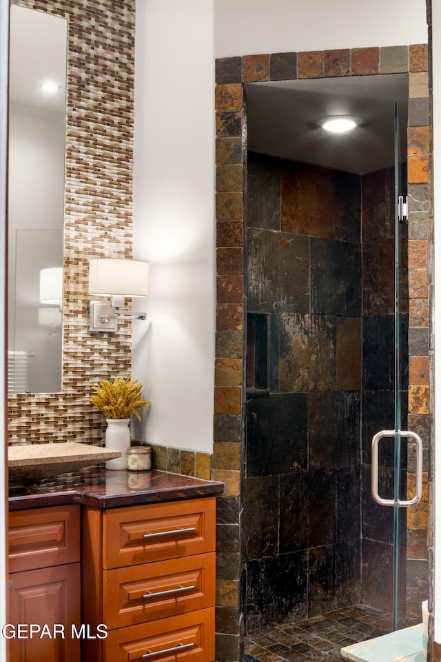 bathroom with decorative backsplash and a shower stall