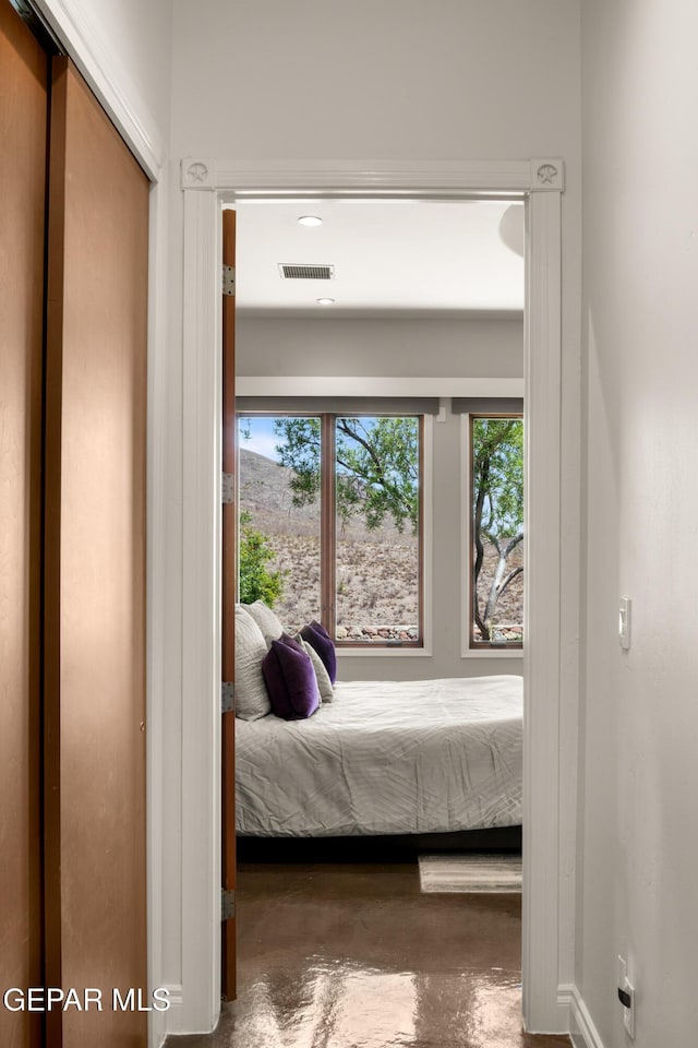 bedroom with baseboards, concrete floors, and visible vents