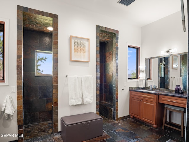 full bath featuring a walk in shower, plenty of natural light, and stone tile flooring