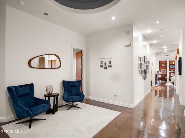 sitting room featuring recessed lighting, baseboards, and finished concrete floors