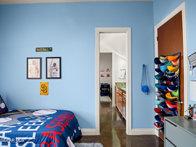 bedroom featuring finished concrete flooring and baseboards