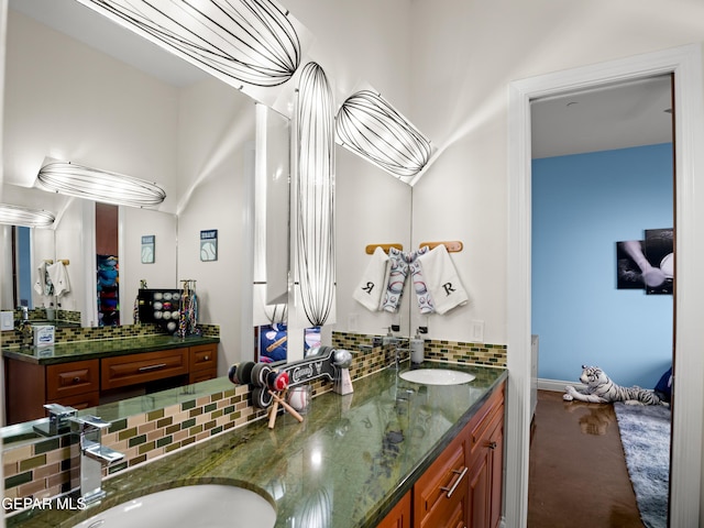 full bath with a sink, decorative backsplash, and double vanity